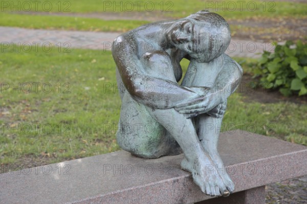 Sculpture Resting by August-Martin Hoffmann 1976, bronze sculpture, seated female figure on bench with head resting on knees, relax, resting, relaxing, silence, calm, contentment, joy, resting, legs, Schelfkirche, St. Nikolai, Schelfstadt, Schwerin, Mecklenburg-Vorpommern, Germany