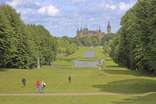 Castle garden with pedestrians and castle, Schwerin, Mecklenburg-Vorpommern, Germany