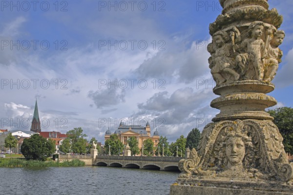 View over castle lake to the castle bridge with relief, detail, putti, face, children, figures, columns, street lamp tower of the cathedral, state theatre, riverside promenade, cityscape, Schwerin, Mecklenburg-Western Pomerania, Germany