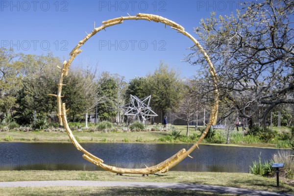 New Orleans, Louisiana - The sculpture garden at the New Orleans Museum of Art in City Park. Alu Truss Star by Frank Stella (across the water) is framed by The Sun by Ugo Rondinone