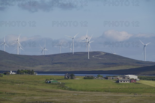 Wind farm on green hills under blue sky with clouds, rural environment, Shetland Islands, Scotland, United Kingdom
