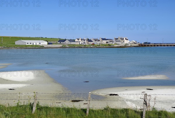Coastline with sand and village by the shimmering blue sea, Pierowal, Westray, Orkney Islands, Scotland, Great Britain