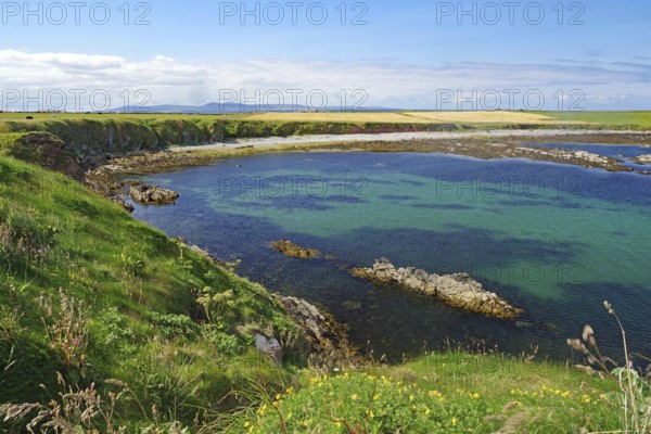 Picturesque bay with clear water, surrounded by green cliffs and wide skies, Pierowal, Westray, Orkney Islands, Scotland, United Kingdom