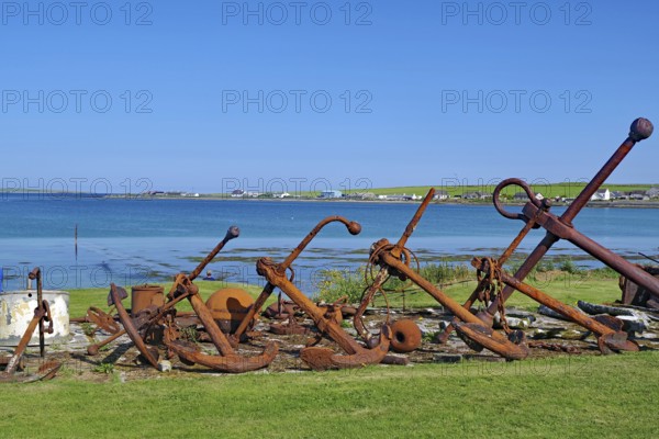 Rusty anchors in a meadow on the coast with sea in the background, Pierowal, Westray, Orkney Islands, Scotland, Great Britain