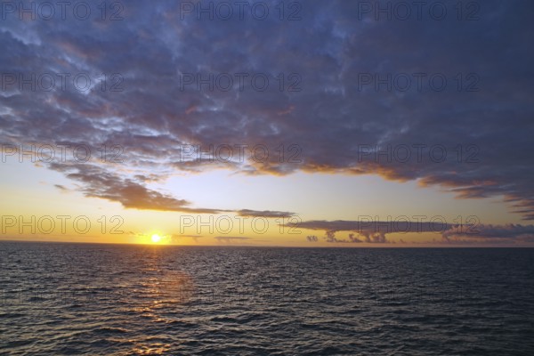 View of the sea at sunset with clouds and colourful sky, crossing between Orkney and Shetland Islands, Scotland, Great Britain