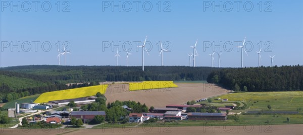 Landscape with wind turbines above agricultural fields and farms in front of a blue sky, near Böhmenkirch, Swabian Alb, Baden-Württemberg, Germany