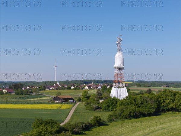 Landscape with transmission tower and many wind turbines surrounded by fields, radio tower being renovated, near Hohenstadt, Swabian Alb, Baden-Württemberg, Germany