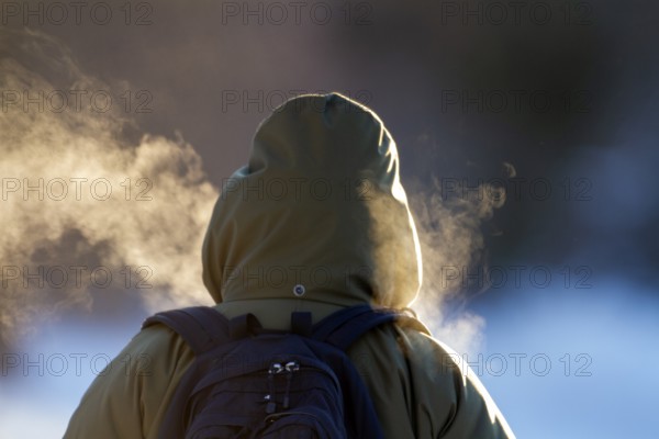 Person walking in very cold weather, Visual effect of the steam seen when exhaling in cold weather. City of Montreal, Province of Quebec, Canada, North America