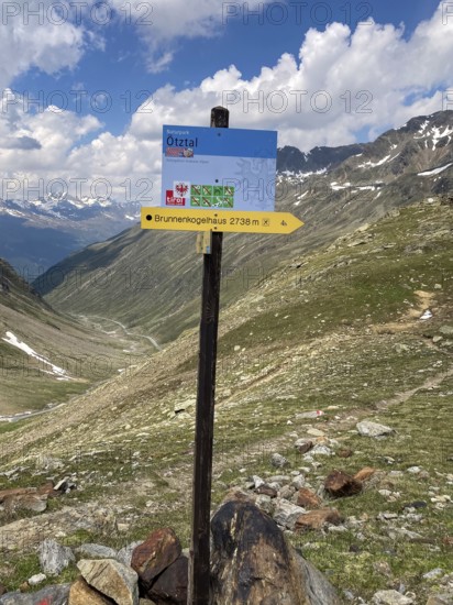 Information board at the top of the Timmelsjoch Passo del Rombo Pass Signpost with the words Ötztal, below sign in the shape of an arrow Signpost to mountain hut Shelter for hikers with the words Brunnenkogelhaus 2738 m, Timmelsjoch, Sölden, Austria