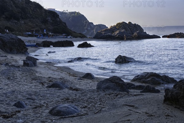 Coastline at dawn with dark rocks and calm sea, Ricadi, Capo Vaticano