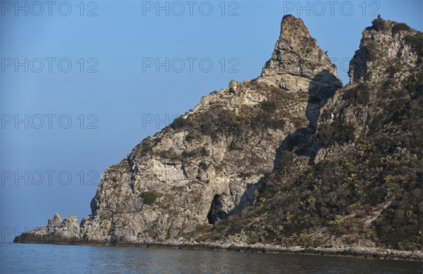 Steep rock formations on the edge of the blue sea under a clear sky, Ricadi, Capo Vaticano