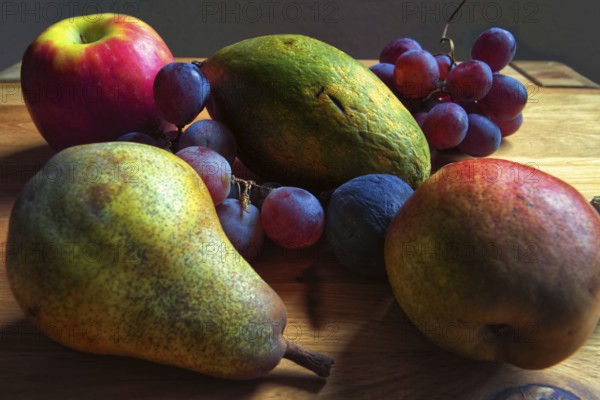 Colourful composition of pears, grapes and apples on a wooden table, Willich, North Rhine-Westphalia