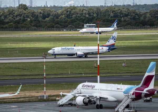 Düsseldorf Airport, Eurowings Airbus aircraft on the apron, SunExpress Boeing 737 on take-off, AnadoluJet on landing, North Rhine-Westphalia, Germany