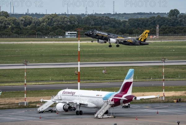 Düsseldorf Airport, Eurowings aircraft taking off, Eurowings Airbus on the apron, BVB Borussia Dormtund branding, team bus, North Rhine-Westphalia, Germany