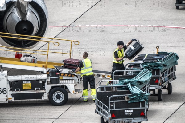 Aircraft being unloaded after landing, luggage being loaded, Düsseldorf International Airport. Düsseldorf, North Rhine-Westphalia, Germany