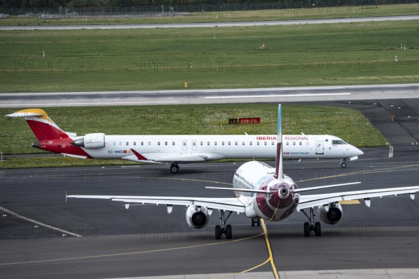 Düsseldorf Airport, Iberia Regional Mitsubishi CRJ-1000, Air Nostrum, on the way to take-off, Eurowings Airbus aircraft, North Rhine-Westphalia, Germany