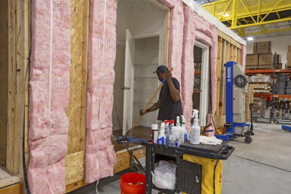 Romulus, Michigan - Workers build apartments in Ginosko Modular 's factory using modular construction methods. A finished modular unit is cleaned before shipping. The units will be assembled into an apartment building in Detroit for low to moderate income households