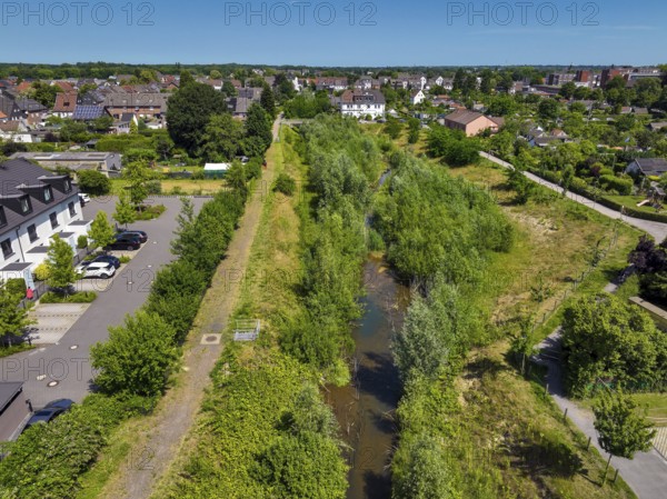 Recklinghausen, North Rhine-Westphalia, Germany - Renaturalised Hellbach, renaturalised watercourse, the Hellbach is now free of wastewater after the construction of a parallel sewer, is part of the Emscher river system and thus part of the Emscher conversion, was previously an open, above-ground wastewater channel, mixed water channel with surface water and wastewater. The renaturalised Hellbach stream strengthens the city's climate resilience, promotes biodiversity and helps to mitigate urban warming caused by climate change