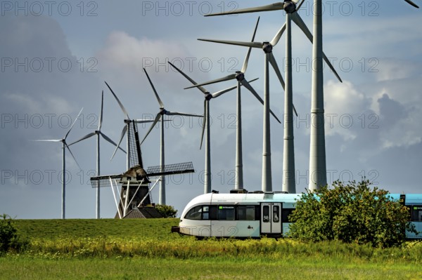 Westereems and Growind wind farms, over 80 wind turbines in total, at Eemshaven seaport, province of Groningen, in the north-west of the Netherlands, historic Goliath windmill, dating from 1897, train connection to Eemshaven seaport, in the Ems estuary, the British transport company Arriva operates a train connection from Groningen Centraal station