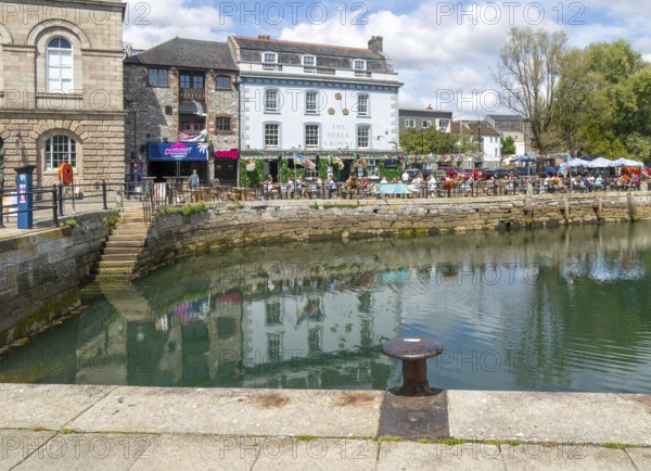 People sitting outside The Three Crowns pub quayside harbour, The Barbican, Plymouth, Devon, England, UK