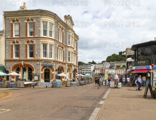 Offshore bar and restaurant, people walking near quayside shops, Vaughan Parade, Torquay, Devon, England, UK