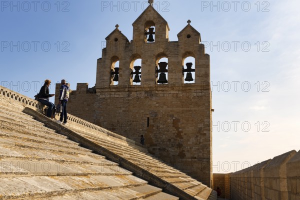 Bell tower of Notre-Dame-de-la-Mer church, two tourists enjoying the view from the roof of the fortified church, Saintes-Maries-de-la-Mer, Camargue, France