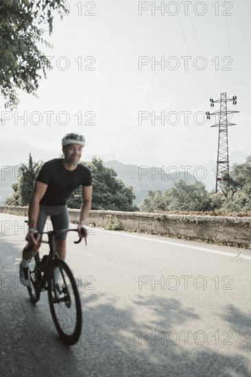 Young man riding a racing bike on Lake Garda. Sunny weather and dolce vita