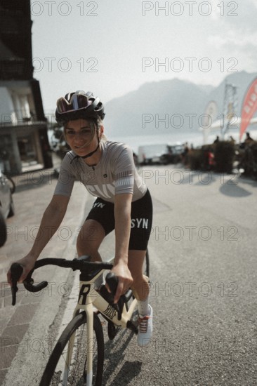 Young woman riding a racing bike on Lake Garda. Sunny weather and dolce vita