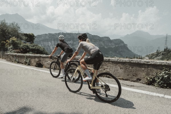 Woman and man cycling on Lake Garda in Italy. Sunny weather and dolce vita
