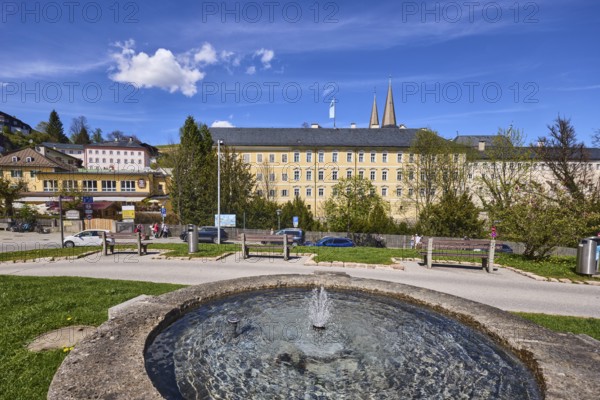Royal Castle Berchtesgaden, Fischerbrunnen, master stonemason August Wolf, fountain, fountain made of stone, general architecture, trees, lawn, parking strip with vehicles, wooden fence, lantern, benches, blue sky, cumulus clouds, cirrostratus clouds, Am Fischerbichl, Bahnhofstraße, Berchtesgaden, Upper Bavaria, district Berchtesgadener Land, Bavaria, Germany
