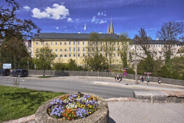 Royal Castle Berchtesgaden, general architecture, trees, lawn, wooden fence, parking strip with vehicles, pedestrians as secondary motif, flower pot, garden pansy (Viola ×wittrockiana), blue sky, cumulus clouds, cirrostratus clouds, Am Fischerbichl, Bahnhofstraße, Berchtesgaden, Upper Bavaria, district Berchtesgadener Land, Bavaria, Germany