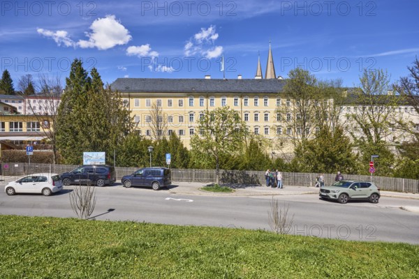Royal Castle Berchtesgaden, general development, lawn, parking lane with vehicles, wooden fence, trees, pedestrians as secondary motif, blue sky, cumulus clouds, cirrostratus clouds, Am Fischerbichl, Bahnhofstraße, Berchtesgaden, Upper Bavaria, district Berchtesgadener Land, Bavaria, Germany