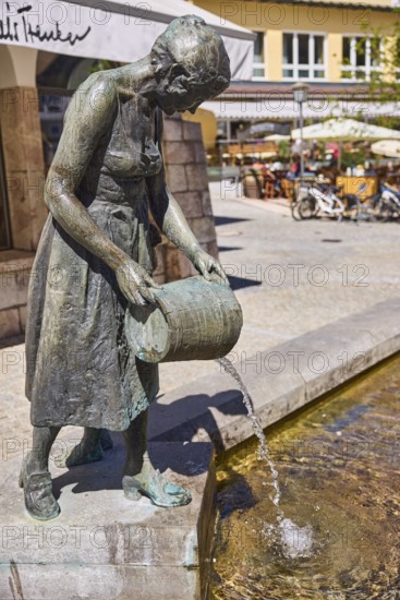 Mother-child fountain, sculptor Fritz Schelle, fountain with bronze sculptures, square, outdoor area of a restaurant with parasols, general architecture, depth of field, market square, Metzgerstraße, Berchtesgaden, Upper Bavaria, district of Berchtesgadener Land, Bavaria, Germany