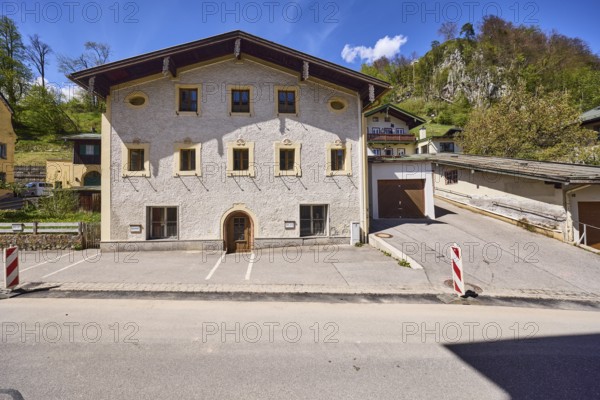 Historic building, garage, facade, window, door, mountain landscape, hill, forest, barrier beacons, blue sky, cumulus clouds, cirrostratus clouds, town hall square, Berchtesgaden, Upper Bavaria, district Berchtesgadener Land, Bavaria, Germany