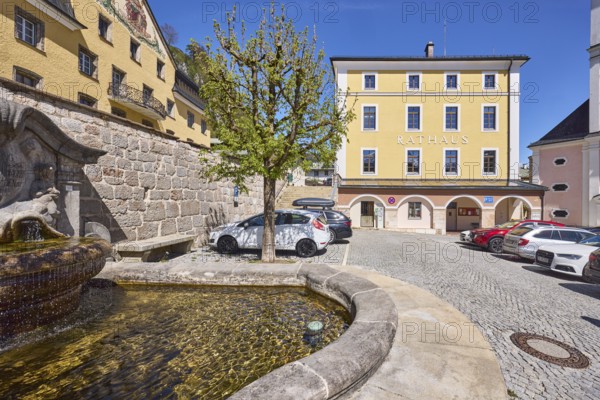 Town hall, fountain at the town hall square, quarry stone wall, car park, vehicles, tree, square, cobblestones, blue sky, cloudless, town hall square, Berchtesgaden, Upper Bavaria, district Berchtesgadener Land, Bavaria, Germany
