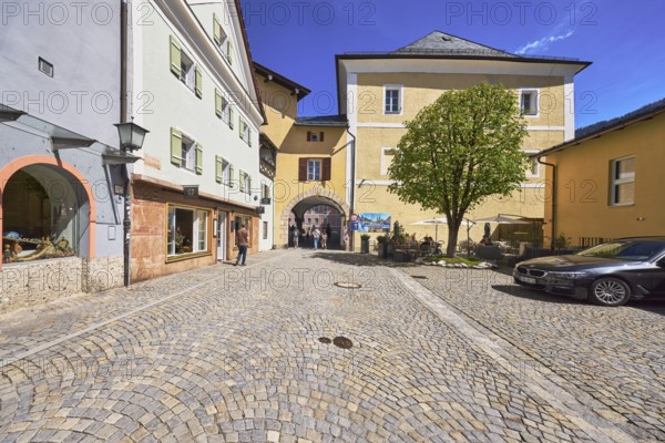 Historic buildings, square, cobblestones, lantern, tree, archway, pedestrian as secondary motif, blue sky, cirrostratus clouds, Schlossplatz, Berchtesgaden, Upper Bavaria, district Berchtesgadener Land, Bavaria, Germany