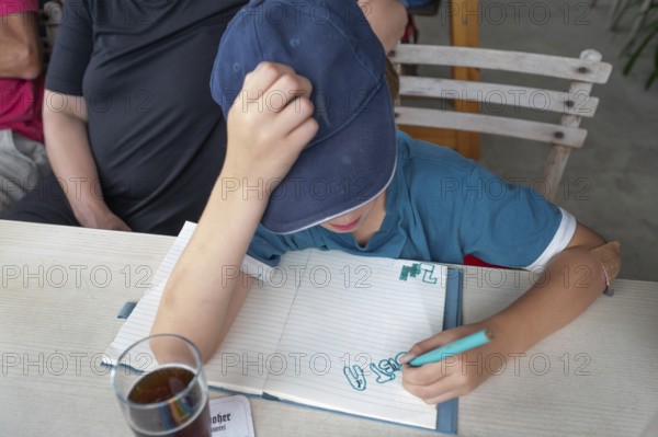 Child painting to pass the time in a neighbourhood, Bavaria, Germany