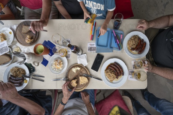 Eating in a pub in Middle Franconia, sausages with sauerkraut and bread, child painting at the table, Middle Franconia, Bavaria, Germany