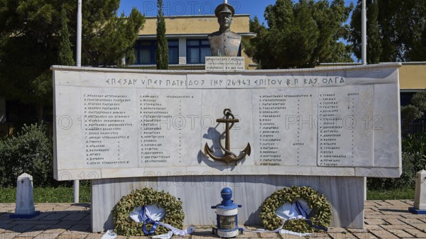 A monument with bust and anchor in the centre, surrounded by plaques with inscriptions and wreaths, photos relating to WW2, Battle of Leros, Portolago, Lakki, Leros, Dodecanese, Greek Islands, Greece
