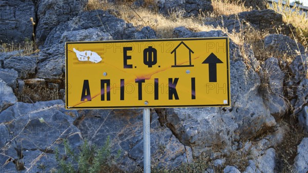 Apitiki, Bunker, Yellow sign with Greek inscription and arrow in front of a rock face, Photos related to WW2, Battle of Leros, Leros, Dodecanese, Greek Islands, Greece