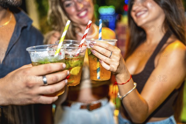 Friends enjoying refreshing cocktails together at a lively summer party, celebrating and having a good time