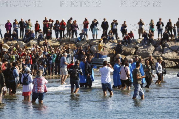 Pilgrimage, procession by the sea, pilgrims walking through water, statue of the Virgin Mary, crowd, Saintes-Maries-de-la-Mer, Camargue, France