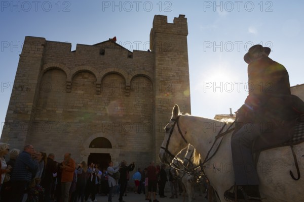 Guardian of the Camargue, rider on Camargue horse in front of the church, sunbeams, backlight, pilgrimage, procession in Saintes-Maries-de-la-Mer, Camargue, France