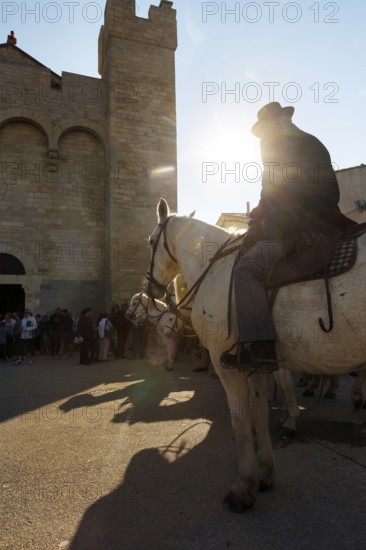Guardian of the Camargue, rider on Camargue horse in front of the church, sunbeams, pilgrimage, procession in Saintes-Maries-de-la-Mer, Camargue, France