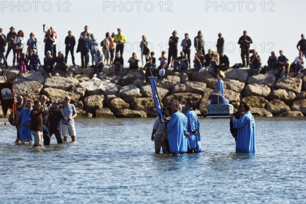 Pilgrimage, procession by the sea, pilgrims walking through water, statue of the Virgin Mary, crowd of spectators, Saintes-Maries-de-la-Mer, Camargue, France