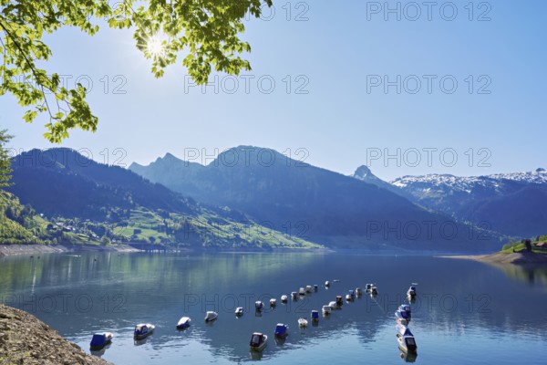 Motorboats moored at the reservoir, snow-covered Alps in the background, Lake Wägital, Canton Schwyz, Switzerland