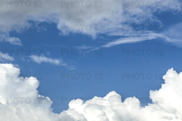 Below white cumulus clouds Cumulus clouds above grey stratocumulus framing blue sky, international