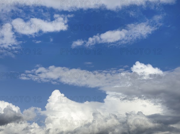 Below white cumulus clouds, centre above stratocumulus above altostratus in front of blue sky, International