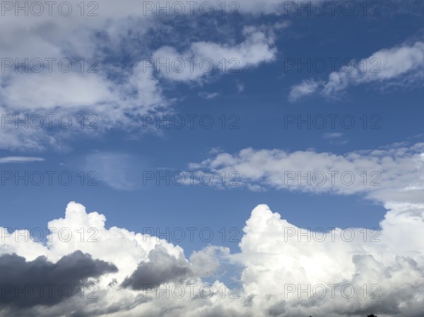 Below grey white stratocumulus clouds, middle above stratocumulus above altostratus in front of blue sky, International