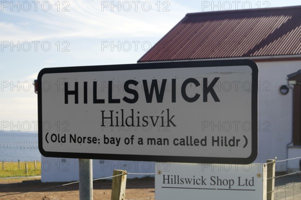 Hillswick town sign in front of a building with historical reference to Old Norse names, Eshaness, Shetland Islands, Scotland, United Kingdom